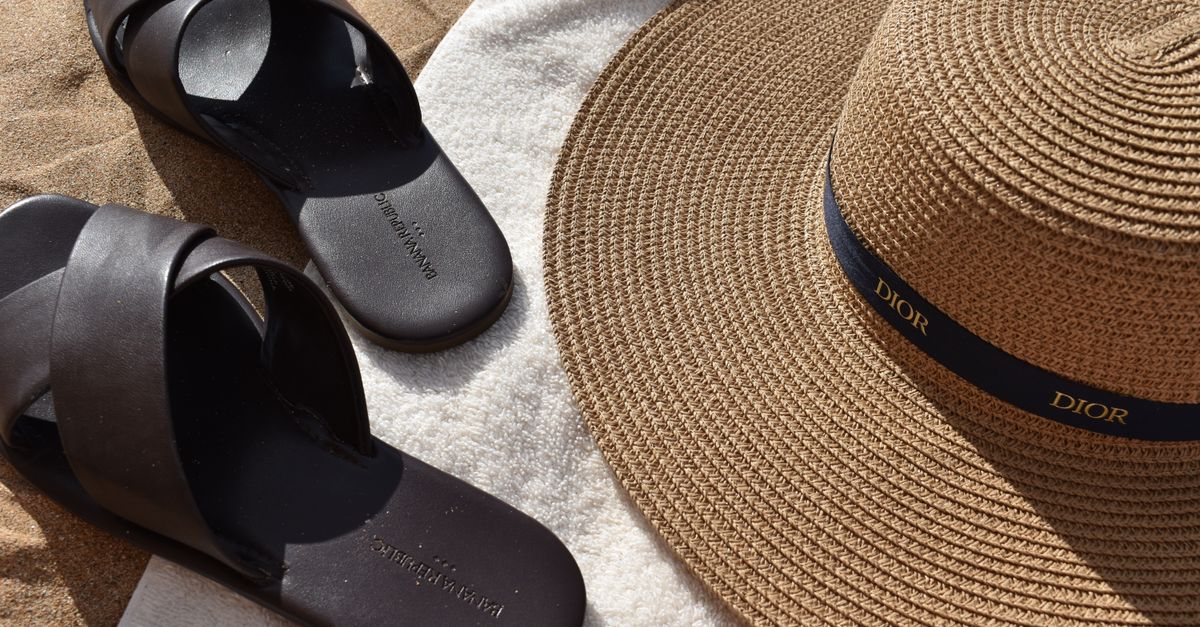 Sun hat and sandals on a beach towel