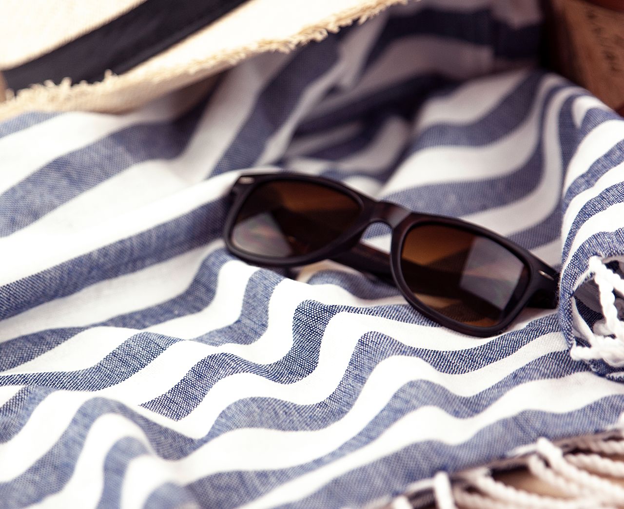 Striped beach towel with sunglasses, ready for summer